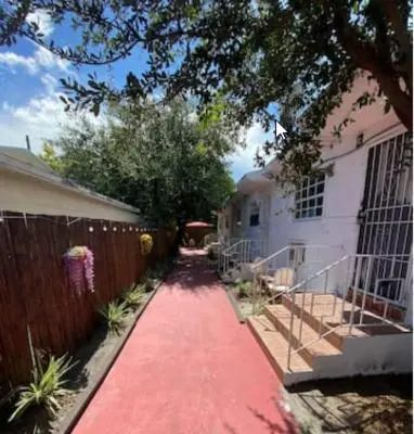 a red carpeted walkway in front of a house at Small House Near Airport Beach - Wynwood in Miami