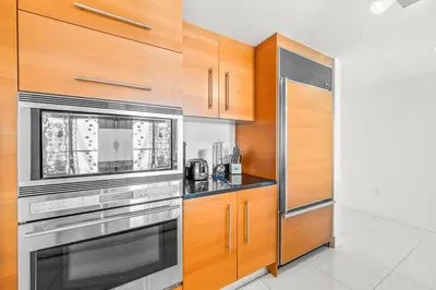 a kitchen with stainless steel appliances and wooden cabinets at Gorgeous Unit At The W Building Priceless Location in Miami