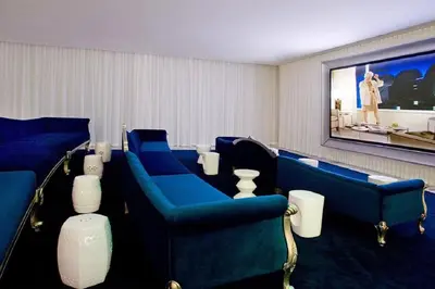 a waiting room with blue chairs and a large screen at Gorgeous Unit At The W Building Priceless Location in Miami