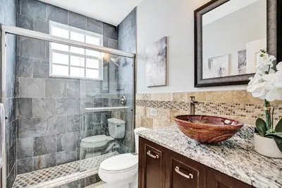 a bathroom with a toilet and a sink at Spacious home wprivate pool game room in Plantation
