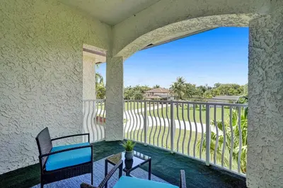 a room with a balcony with a table and chairs at Spacious home wprivate pool game room in Plantation