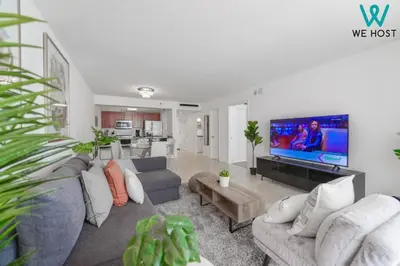a living room with a couch and a flat screen tv at Wonderful Condo in Brickell With Pool and Gym in Miami
