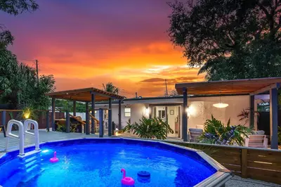 a swimming pool in front of a house with a sunset at Swim, Dine, and Relax - Your private paradise awaits in Fort Lauderdale