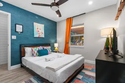 a bedroom with a large bed and a blue wall at Swim, Dine, and Relax - Your private paradise awaits in Fort Lauderdale