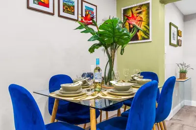 a dining room with a glass table and blue chairs at Swim, Dine, and Relax - Your private paradise awaits in Fort Lauderdale