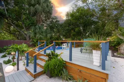 a wooden deck with a swimming pool and trees at Swim, Dine, and Relax - Your private paradise awaits in Fort Lauderdale