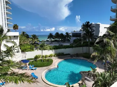 a view of the pool from the balcony of a resort at Hollywood Beach Ocean View Condo, Direct Beach Access, Pool & Resort Amenities in Hollywood