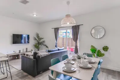a living room with a table and a blue couch at Amazing Townhouse 15 minutes from the Beach in Miami