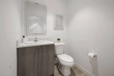 a white bathroom with a toilet and a sink at Amazing Townhouse 15 minutes from the Beach in Miami