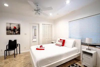 a bedroom with a white bed with a ceiling fan at B efficiency Off Las Olas on water free kayaks in Fort Lauderdale