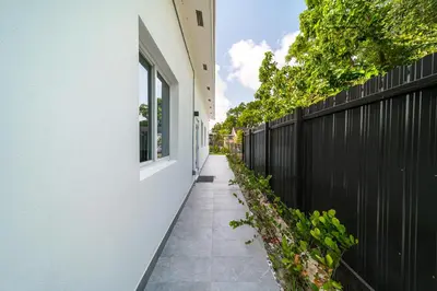 a sidewalk next to a fence next to a house at Pool Boutique Villa by the Beach 1 in Hallandale Beach