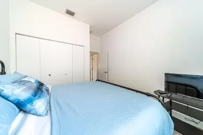 a bedroom with a bed and a flat screen tv at Pool Boutique Villa by the Beach 1 in Hallandale Beach