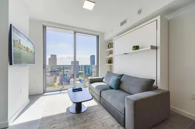 a living room with a couch and a large window at Stylish Stay in the Heart of Miami - Walk to Bayside & Bayfront Park in Miami