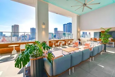 a room with chairs and tables and a large window at Stylish Stay in the Heart of Miami - Walk to Bayside & Bayfront Park in Miami