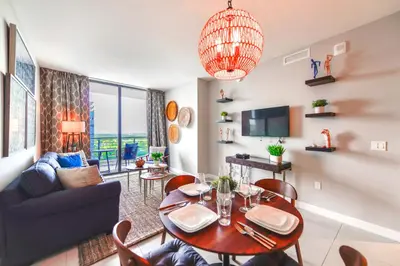 a living room with a table and a couch at Modern Hotel with Pool & Gym in Prime Doral Location in Miami