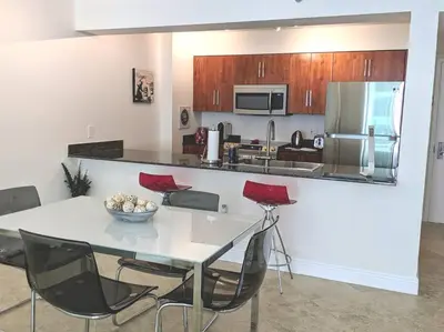 a kitchen with a table and red chairs in a room at Condo in Brickell Business District in Miami