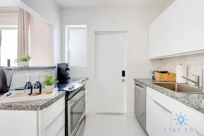 a white kitchen with white cabinets and a sink at Free Parking, Bay View, Pool, Step To Beach in Hollywood