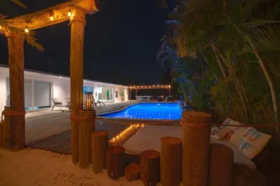 a backyard with a swimming pool at night at Heated pool in a Precious House close to Zoo Parks and Arts in Cutler Bay