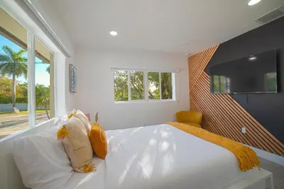 a bedroom with a large white bed with yellow pillows at Heated pool in a Precious House close to Zoo Parks and Arts in Cutler Bay