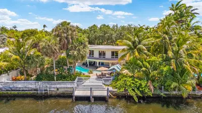 an aerial view of a house with palm trees at Waterfront Retreat: 7BR Villa with Pool Firepit in Fort Lauderdale