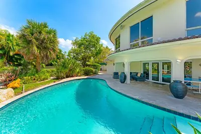 a swimming pool in front of a house at Waterfront Retreat: 7BR Villa with Pool Firepit in Fort Lauderdale