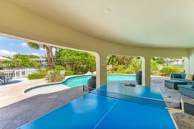a house with a swimming pool and a table at Waterfront Retreat: 7BR Villa with Pool Firepit in Fort Lauderdale