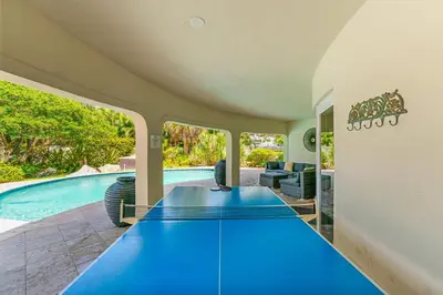 an indoor pool with blue ping pong tables at Waterfront Retreat: 7BR Villa with Pool Firepit in Fort Lauderdale