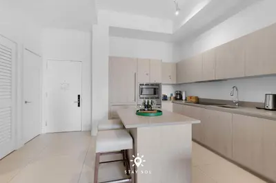 a white kitchen with a counter and a microwave at Beachfront Condo - Amazing Pool - Oceanview Balcony in Hollywood
