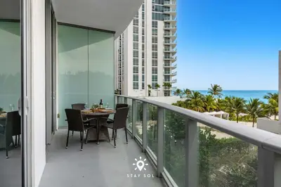 a balcony with a table and chairs and the ocean at Beachfront Condo - Amazing Pool - Oceanview Balcony in Hollywood