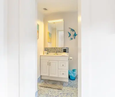 a bathroom with a sink and a mirror at Fun Family-Friendly Poolside Escape Near Beach in Dania Beach
