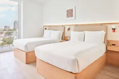 two beds in a hotel room with a window at Arlo Wynwood Miami in Miami