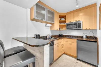 a kitchen with wooden cabinets and a counter top at Eternal Sunrise Suite in Fort Lauderdale
