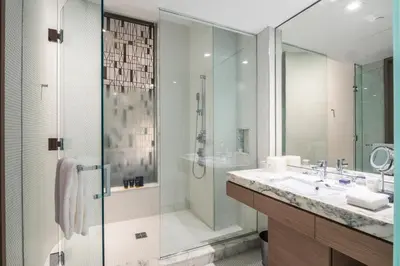 a bathroom with a glass shower and a sink at Suites at SLS Lux Brickell managed by CE in Miami