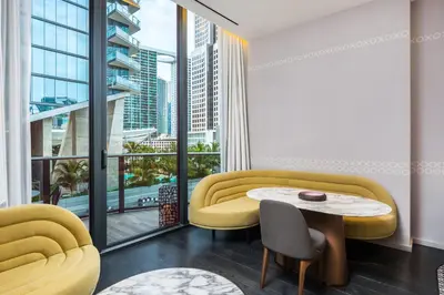 a living room with a table and a large window at Suites at SLS Lux Brickell managed by CE in Miami