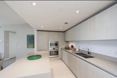 a kitchen with white cabinets and a green plate on the counter at Ocean View Beachfront 2Bed/2B M-Penthouse @HYDE in Hollywood