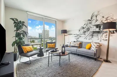 a living room with a couch and a large window at Nomada Destination Residences - Quadro in Miami