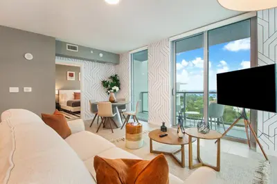 a living room with a white couch and a flat screen tv at Nomada Destination Residences - Quadro in Miami