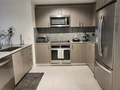a kitchen with wooden cabinets and a stainless steel refrigerator at DOWNTOWN DORAL, FLORIDA. NEW CONDO STYLE RESORT. in Miami