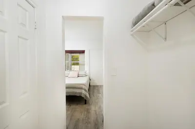 a bedroom with white walls and a bed in a room at The Oasis in Miami
