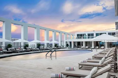 a hotel with a pool with lounge chairs and umbrellas at Studio Suite at Fort Lauderdale in Fort Lauderdale