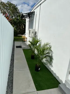 a garden with two potted plants next to a white wall at LYZ Miami Airport in Miami