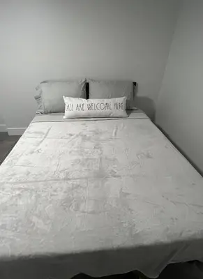 a white bed with a pillow on top of it at LYZ Miami Airport in Miami
