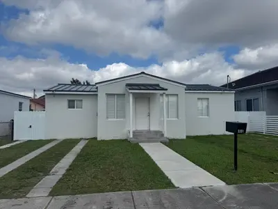 a white house with a white fence at LYZ Miami Airport in Miami