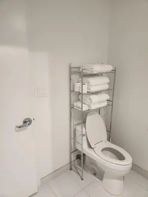 a bathroom with a toilet and a rack of towels at Wonderful 1 bedroom condo in Midtown. in Miami