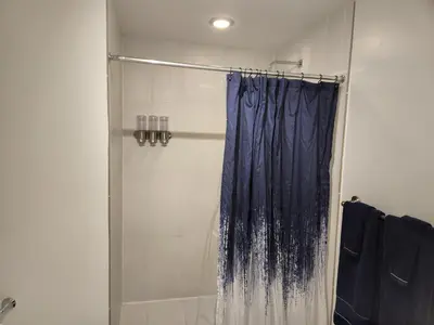 a shower with a blue shower curtain in a bathroom at Wonderful 1 bedroom condo in Midtown. in Miami