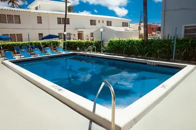 a swimming pool with lounge chairs next to a building at Ocean Sound's Hotel in Hollywood
