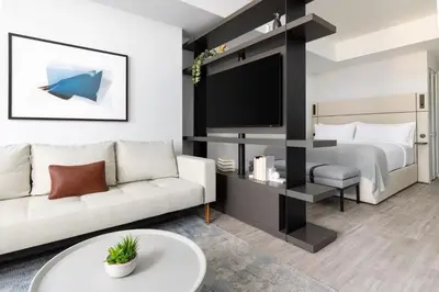 a living room with a bed and a tv at The Elser Hotel Miami - An All-Suite Hotel in Miami