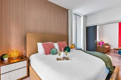 a bedroom with a large bed and a living room at Cozy Apartment - Hot Tub - NearBeach - Broad - walk in Hollywood