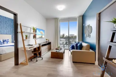 a bedroom with a bed and a desk and a desk at Exclusive Apartment - Rooftop Pool - Hollywood Beach in Hollywood