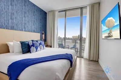 a bedroom with a large bed and a large window at Exclusive Apartment - Rooftop Pool - Hollywood Beach in Hollywood